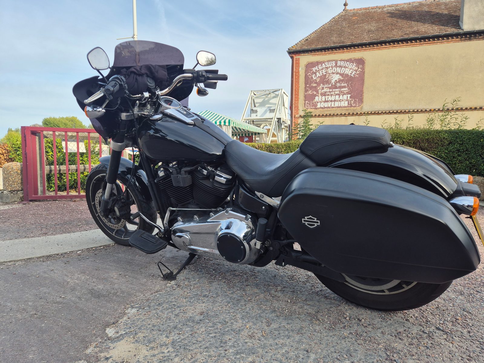 A black Harley-Davidson motorcycle parked outside the Café Gondrée at Pegasus Bridge in France.